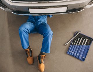 Hombre reparando debajo de un coche Talleres Cristian Irun