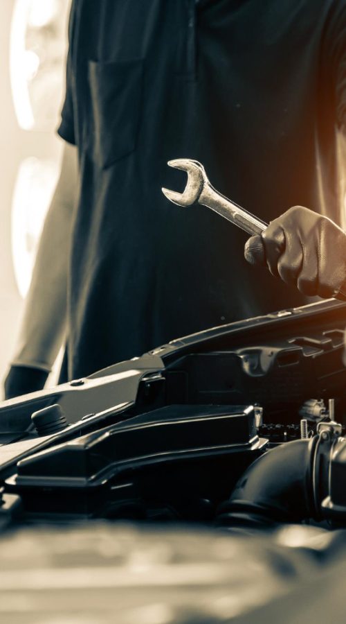 Un hombre coge una herramienta para reparar un coche Talleres Cristina Irun